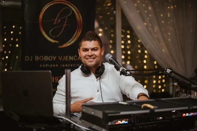 DJ Boboy nasmijan za DJ pultom na vjenčanju