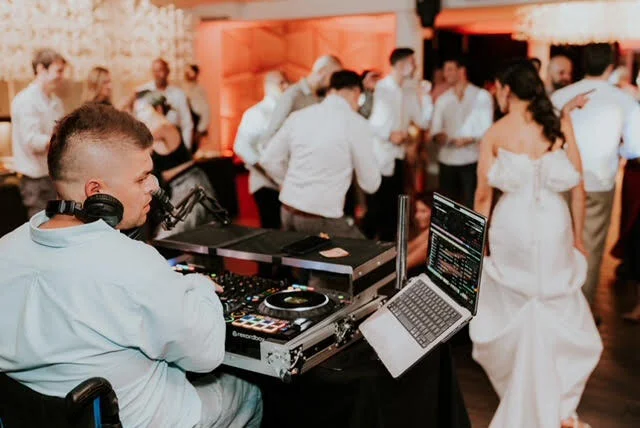 DJ Boboy za pultom dok gosti plešu - DJ za svadbe i evente